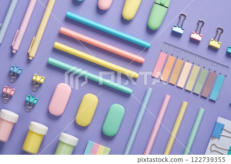 Stationery background with pastel-colored stationery neatly arranged on a light purple background. Stationery background with pastel-colored stationery neatly arranged on a light purple background. 122739355