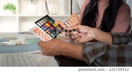 Diverse team evaluating color palettes for graphic design project. Diverse team evaluating color palettes for graphic design project. 122739522