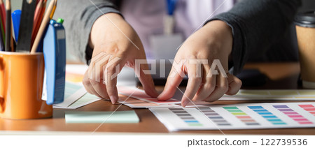 Hands arranging color palettes for graphic design and visual projects 122739536
