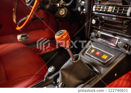 A vintage cars interior features luxurious leather seating and boasts a stylish gear shift for driving pleasures 122740651