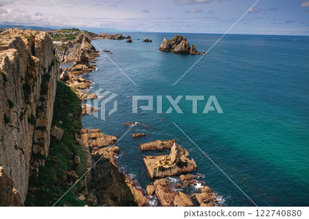 A breathtaking coastal landscape with rugged cliffs and rock formations 122740880