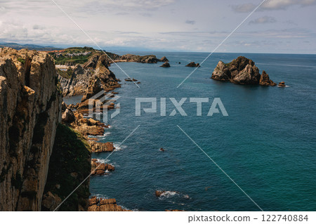 A stunning coastal view with dramatic cliffs and rock formations stretching into the blue ocean A stunning coastal view with dramatic cliffs and rock formations stretching into the blue ocean 122740884