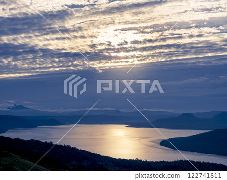 Lake Kussharo sparkling in the light shining through the clouds, seen from Bihoro Pass in the early morning 122741811