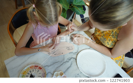 A young mother and her daughter enjoy a creative art session at home  122741903