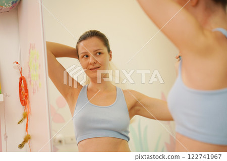 Young woman in a modern bathroom washing her face and brushing her teeth  122741967