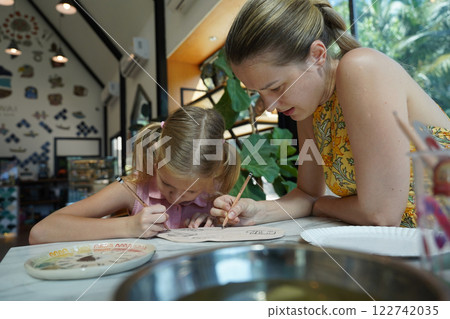 A young mother and her daughter enjoy a creative art session at home A young mother and her daughter enjoy a creative art session at home 122742035