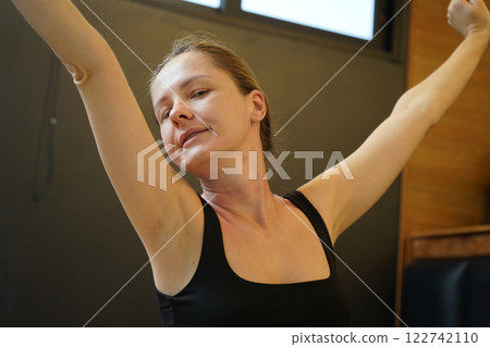 A young woman is enjoying a wonderfully serene morning in her bedroomnd  122742110