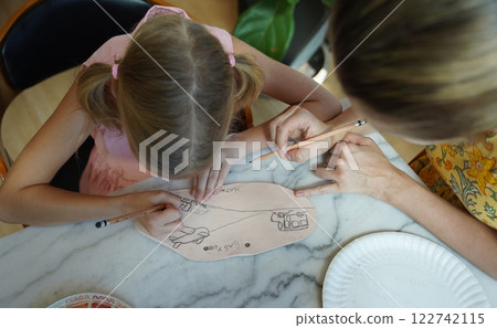 A young mother and her daughter enjoy a creative art session at home A young mother and her daughter enjoy a creative art session at home 122742115