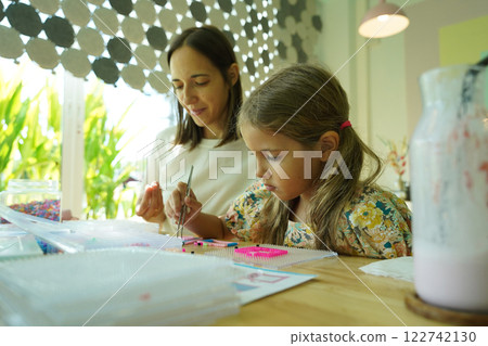 Teacher in workshop teched two girls how to assemble a thermo mosaic Teacher in workshop teched two girls how to assemble a thermo mosaic 122742130