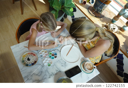A young mother and her daughter enjoy a creative art session at home A young mother and her daughter enjoy a creative art session at home 122742155