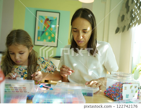 Teacher in workshop teched two girls how to assemble a thermo mosaic Teacher in workshop teched two girls how to assemble a thermo mosaic 122742176