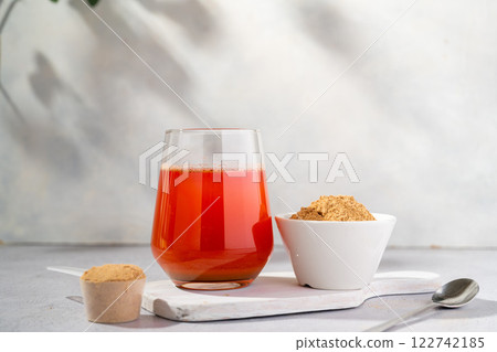 Protein collagen pink powder, fruits and vegetables powder, food supplement in a glass with water 122742185