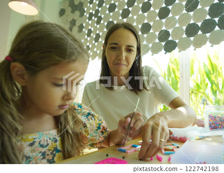 Teacher in workshop teched two girls how to assemble a thermo mosaic  122742198