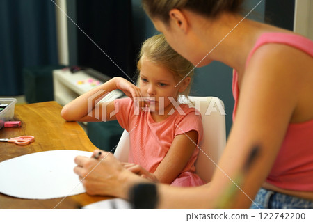A mother and her young daughter engage in a colorful painting activity A mother and her young daughter engage in a colorful painting activity 122742200
