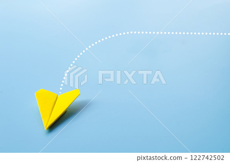 Low view of origami yellow paper airplane on blue background Low view of origami yellow paper airplane on blue background 122742502