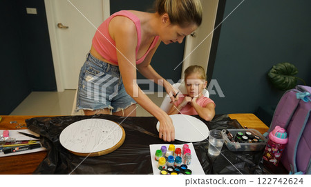 A mother and her young daughter engage in a colorful painting activity A mother and her young daughter engage in a colorful painting activity 122742624