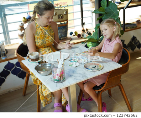 A young mother and her daughter enjoy a creative art session at home  122742662