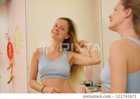 Young woman in a modern bathroom washing her face and brushing her teeth Young woman in a modern bathroom washing her face and brushing her teeth 122742671