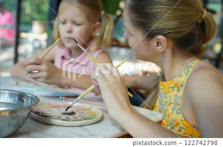 A young mother and her daughter enjoy a creative art session at home A young mother and her daughter enjoy a creative art session at home 122742798