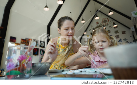A young mother and her daughter enjoy a creative art session at home A young mother and her daughter enjoy a creative art session at home 122742918