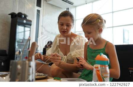 Mother and her daughter paint Halloween cookies Mother and her daughter paint Halloween cookies 122742927