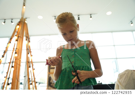 Mother and her daughter paint Halloween cookies  122742935