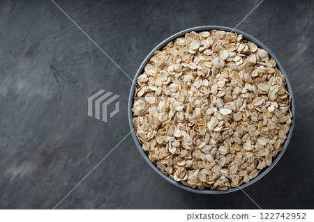 Uncooked Rolled Oats in Bowl for Vegan Breakfast and Weight Loss Nutrition, Copy Space Uncooked Rolled Oats in Bowl for Vegan Breakfast and Weight Loss Nutrition, Copy Space 122742952