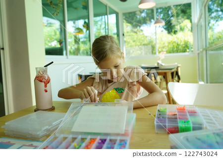 Teacher in workshop teched two girls how to assemble a thermo mosaic  122743024