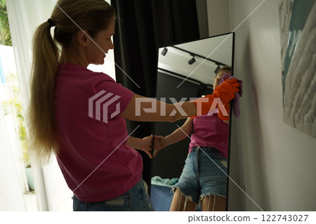 A woman is cleaning her living room at home 122743027