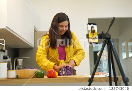 Young woman is broadcasting live from workshop how to prepare a vegetarian food Young woman is broadcasting live from workshop how to prepare a vegetarian food 122743046