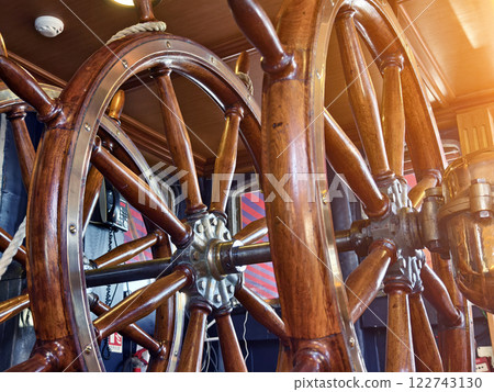 A row of wooden steering wheels located on an old vessel A row of wooden steering wheels located on an old vessel 122743130