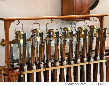 A row of decorative rifles is lined up on a wooden rack 122743286