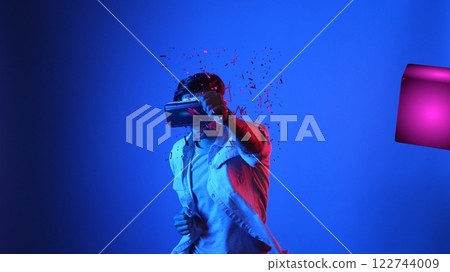 Gamer boxing and punching floating box while wearing VR glasses. Apparatus. 122744009