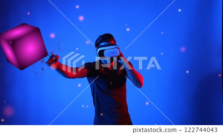 Gamer boxing and punching floating box while wearing VR glasses. Apparatus. 122744043