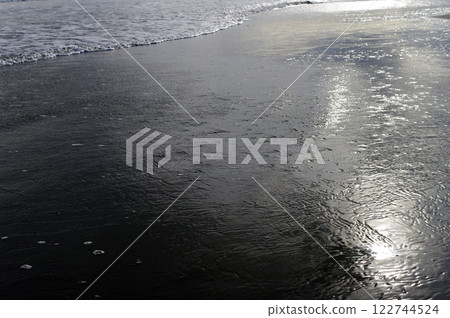 Beyond the vast sandy beach stretches the endless Pacific Ocean. The waves never stop crashing in and then receding. 122744524