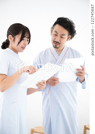 A man receiving health guidance from a public health nurse during a health checkup - Positive 122745687