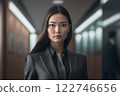 Smart working woman with a business suit is standing and posting in front of a blur office environment background created with generative AI technology 122746656