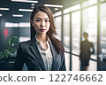 Smart working woman with a business suit is standing and posting in front of a blur office environment background created with generative AI technology 122746662