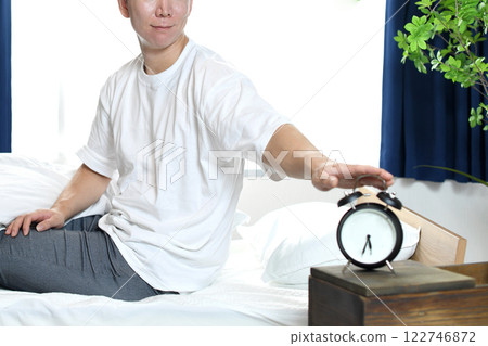 亞洲男子微笑著停下鬧鐘 122746872