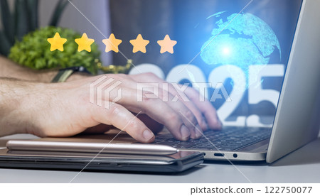 Close-up of hands typing on laptop with year 2025, global holographic projection and five star rating concept for business excellence and digital innovation 122750077