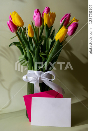 Empty white envelope mock up template Fresh bouquet of colorful tulip flowers in pastel background with shadows. Minimalist design greeting card for springtime holidays. Gift for birthday 8 March 122750105