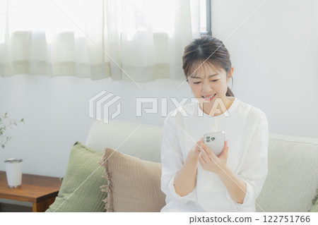 Woman operating a smartphone Woman operating a smartphone 122751766