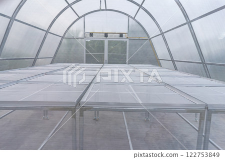 Greenhouse for organic vegetables. The thatched roof will keep out bugs. 122753849