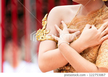 Close up hand of Thai folk dance during celebration on temple background. Thai traditional dance on event celebration. Close up hand of Thai folk dance during celebration on temple background. Thai traditional dance on event celebration. 122753867