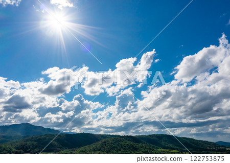 The aerial picture of Hui Kha Khaeng atmosphere, green forest and mountains, in Tak province, Thailand. The enormous wildlife sanctuary environment with sunlight and clouds on the blue sky. 122753875