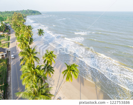 The ariel view of the clear sky with palm trees, fine sand and foam waves splashed to serene beach in Chumphon, Thailand. The ariel view of the clear sky with palm trees, fine sand and foam waves splashed to serene beach in Chumphon, Thailand. 122753886