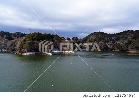 Snow-covered Nara Nunome Dam, with the water's edge covered in snow on the opposite bank of the mountains 122754684