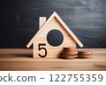 On the tabletop, a small wooden house acts as a symbol, encapsulating the ideas of homeownership, construction, and the financial implications tied to mortgages. Created with generative AI tools 122755359