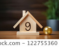 Resting on the table's surface, a tiny wooden house embodies the concepts of homeownership, construction efforts, and the financial obligations related to mortgages. Created with generative AI tools 122755360