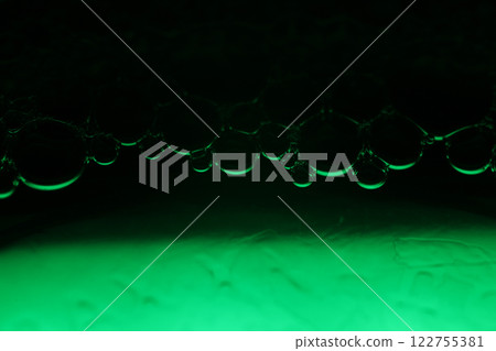 Green liquid surface, fantastic bubbles connections, fluid movement, dark fantastic background, transparent forms, black and green 122755381